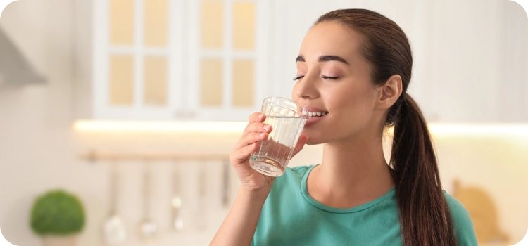 صورة لامرأة تحمل كوبًا من الماء